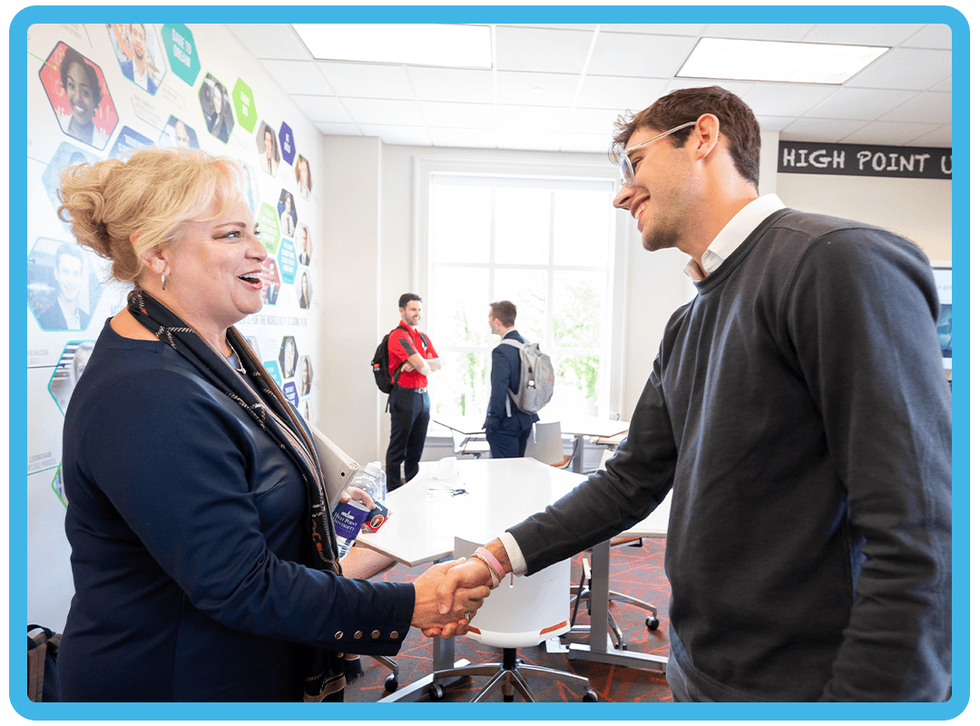 Student and professor shaking hands.